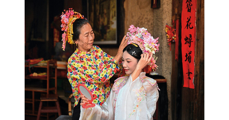 a tourist right wearing flowery headwear xunpu village quanzhou city.jpg